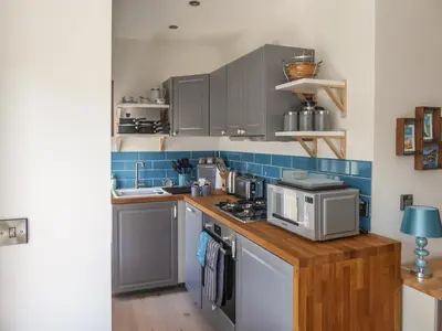 a kitchen with a counter top with a microwave at Harbour View Apartment in Looe