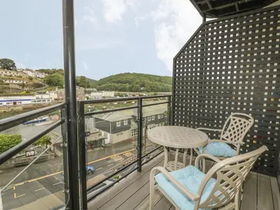 a balcony with a table and chairs and a view at Harbour View Apartment in Looe