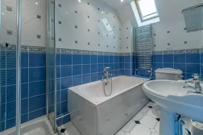 a blue and white bathroom with a tub and a sink at The Summerhouse in Polzeath