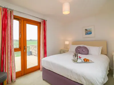 a bedroom with a bed with a tray of fruit on it at Kingcup Cottage in Saint Columb Major