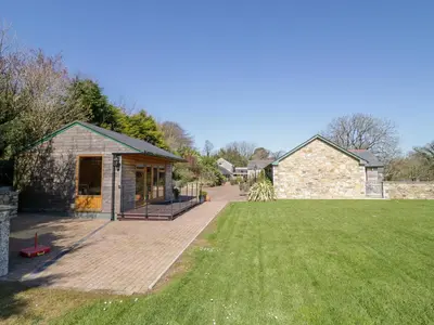 a house with a large lawn in front of it at Kingcup Cottage in Saint Columb Major