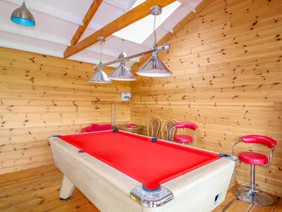 a ping pong table in a room with wooden walls at Kingcup Cottage in Saint Columb Major