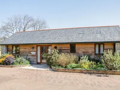 a log cabin with plants in front of it at Kingcup Cottage in Saint Columb Major