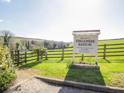 a sign in a field next to a fence at FernGully in Saint Columb Major