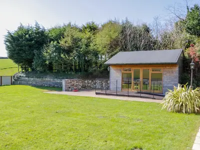a small shed in a garden with a lawn at FernGully in Saint Columb Major
