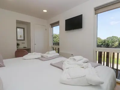 two beds in a room with white towels on them at Willow in Truro