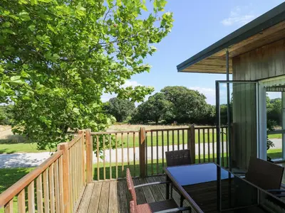 a wooden deck with a table and chairs on it at Willow in Truro