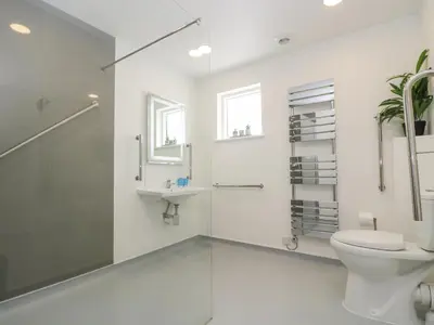 a white bathroom with a toilet and a sink at Willow in Truro