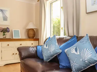 a living room with a brown couch with blue pillows at Deja Blue in Falmouth