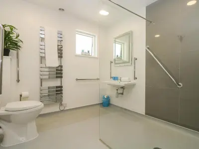 a bathroom with a toilet and a glass shower at Rowan in Truro