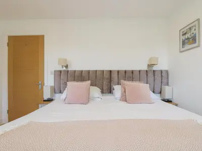 a bedroom with a large bed with pink pillows at Rowan in Truro