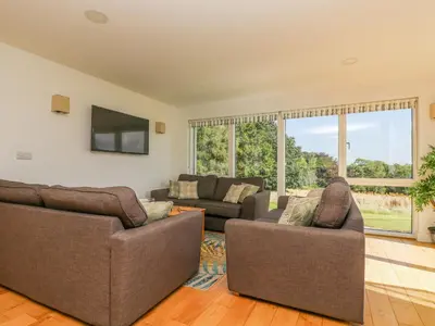 a living room with two couches and a tv at Rowan in Truro