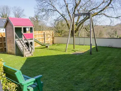 a yard with a playground with a swing at Forget-me-not in Saint Columb Major