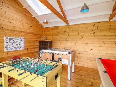 a ping pong table in a room with wooden walls at Forget-me-not in Saint Columb Major