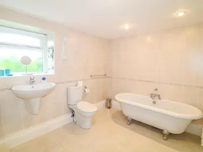 a bathroom with a sink and a tub and a toilet at Forget-me-not in Saint Columb Major