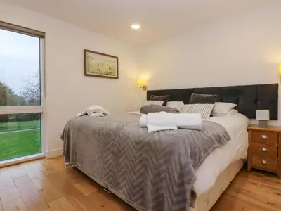 a bedroom with a large bed and a window at Oak in Truro