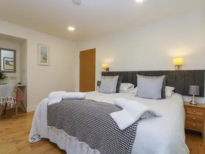 a bedroom with a large bed with white sheets and pillows at Oak in Truro