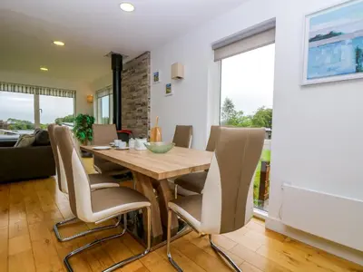 a dining room with a wooden table and chairs at Maple in Truro