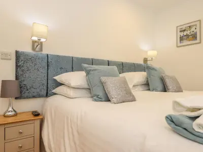 a bedroom with a large white bed with pillows at Maple in Truro