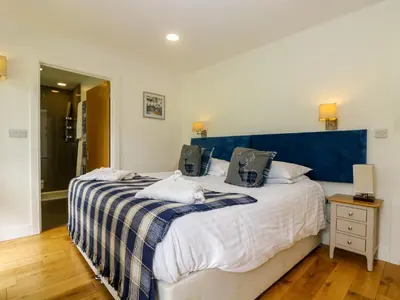 a bedroom with a large bed with a blue headboard at Maple in Truro