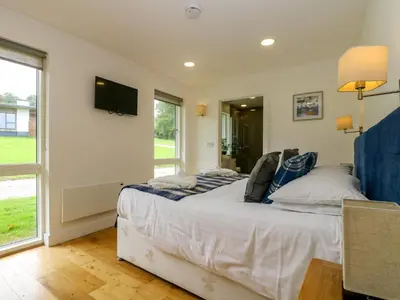 a bedroom with a bed and a tv on the wall at Maple in Truro