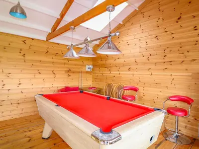 a red pool table in a room with wooden walls at Cornflower Cottage in Saint Columb Major
