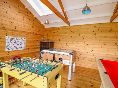 a ping pong table in a room with wooden walls at Cornflower Cottage in Saint Columb Major