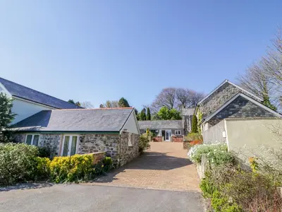 a home with a stone house with a driveway at Cornflower Cottage in Saint Columb Major