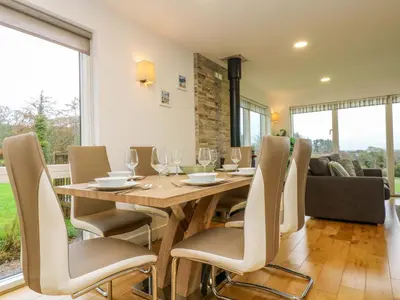 a dining room with a wooden table and chairs at Juniper in Truro