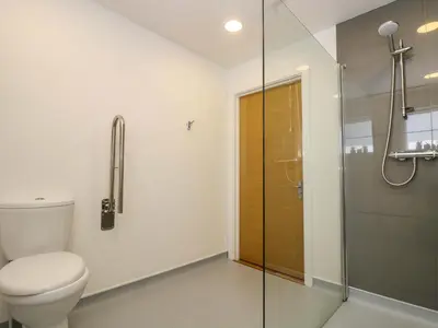 a bathroom with a toilet and a glass shower at Juniper in Truro