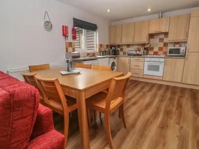 a kitchen with a wooden table and chairs at 64 Waterside in Bodmin