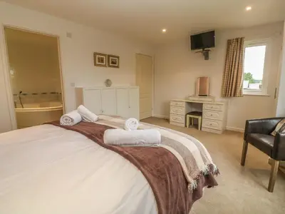 a bedroom with a large bed with towels on it at 64 Waterside in Bodmin