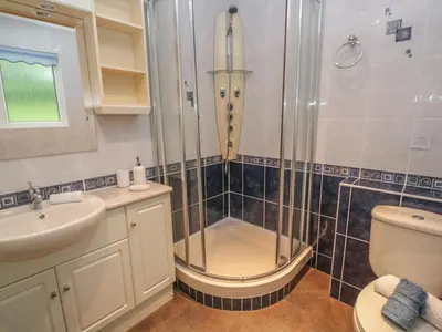 a bathroom with a shower and a sink and a toilet at 64 Waterside in Bodmin