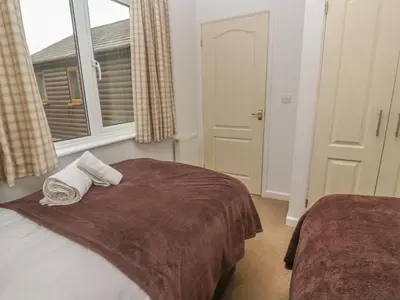 a bedroom with a bed with two towels on it at 64 Waterside in Bodmin