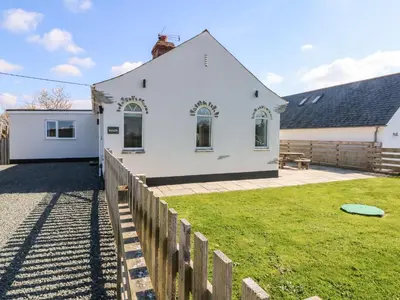 a white house with a fence and a frisbee at Senafe in Bude