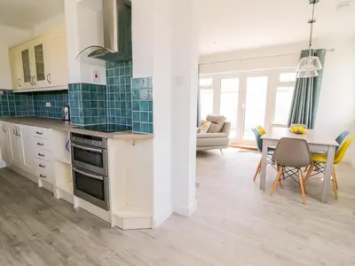 a kitchen and living room with a table and chairs at Senafe in Bude