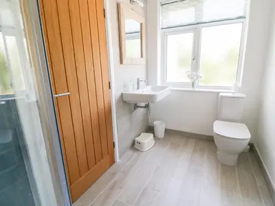 a bathroom with a toilet and a sink and a window at Senafe in Bude