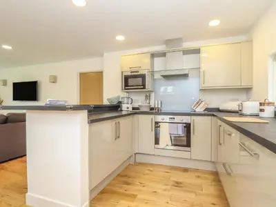 a kitchen with white cabinets and a counter top at Hazel in Truro