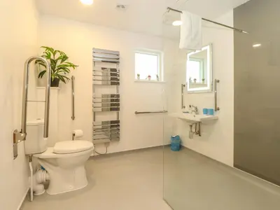a bathroom with a toilet and a shower and a sink at Hazel in Truro