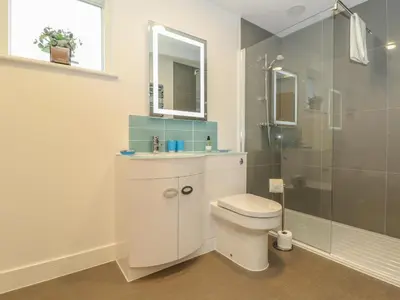 a bathroom with a toilet and a glass shower at Hazel in Truro