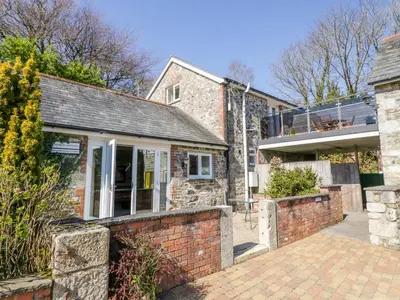 an exterior view of a house with a brick wall at Lambkin Cottage in Saint Columb Major