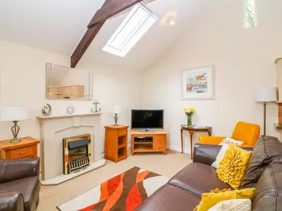 a living room with a couch and a fireplace at Lambkin Cottage in Saint Columb Major