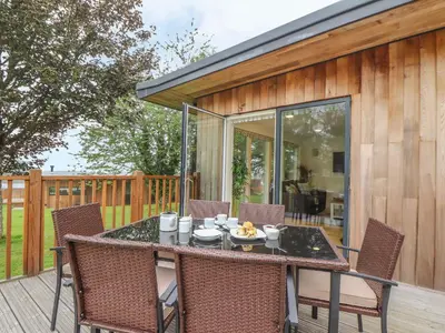 a patio with a table and chairs on a deck at Elm in Truro