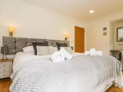 a large white bed with two towels on it at Elm in Truro