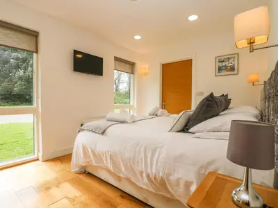 a bedroom with a bed and a tv on the wall at Elm in Truro