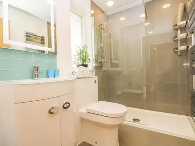 a white bathroom with a toilet and a shower at Elm in Truro