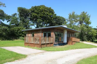 a small house with a porch on a dirt road at Elm in Truro