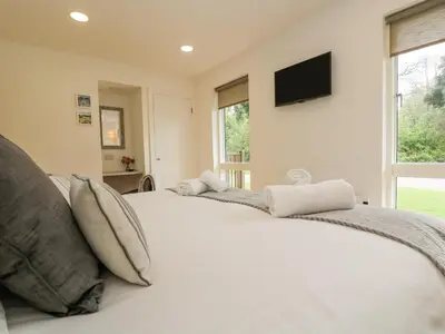a bedroom with two beds and a television on the wall at Birch in Truro