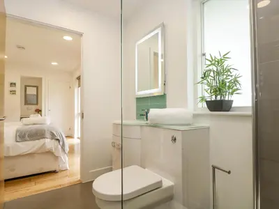 a white bathroom with a toilet and a mirror at Birch in Truro