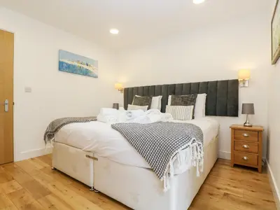 a bedroom with a large white bed and a wooden floor at Beech in Truro